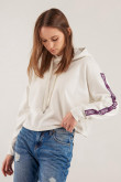 Buzo croptop con capota y cordones, estampado sobre mangas y puños en contraste.