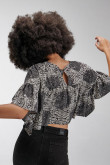 Blusa cuello redondo, con abertura en espalda y abotonadura.
