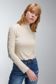 Camiseta unicolor manga larga, con cuello alto y perlas sobre manga.