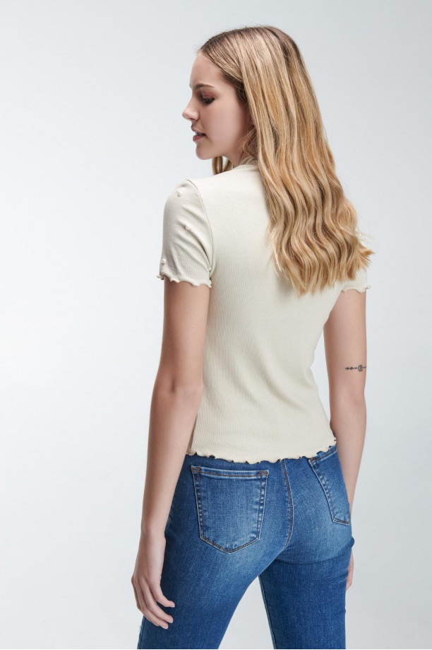 Camiseta femenina unicolor con perlas sobre frente y mangas.