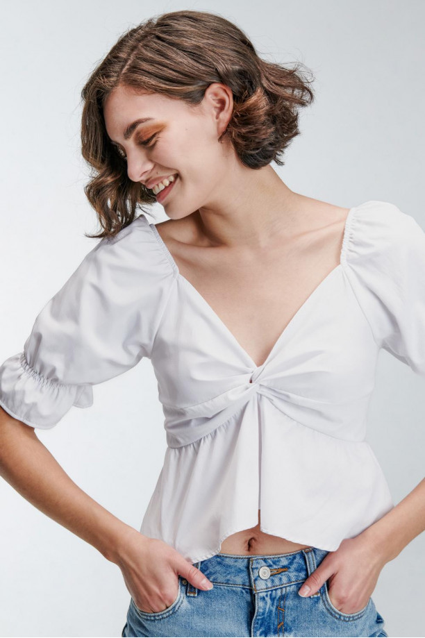Blusa unicolor en tela lisa con escote y mangas con encauchado en puño.