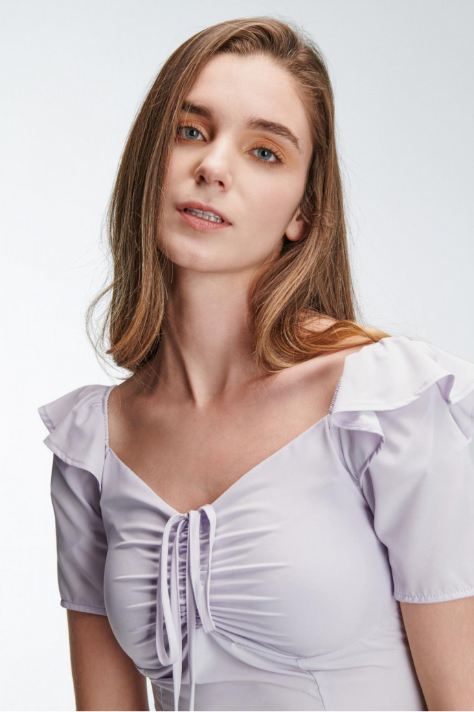 Blusa escotada y ajustada en tela fluida de color sólido, con hombros encauchados.
