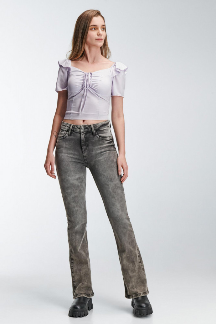 Blusa escotada y ajustada en tela fluida de color sólido, con hombros encauchados.