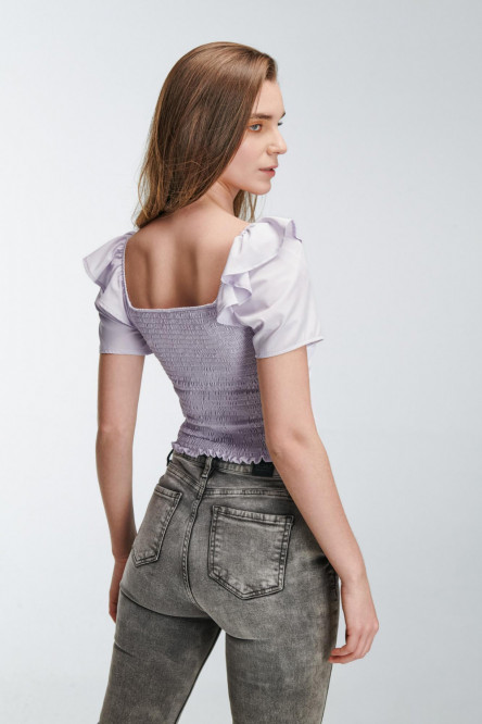 Blusa escotada y ajustada en tela fluida de color sólido, con hombros encauchados.